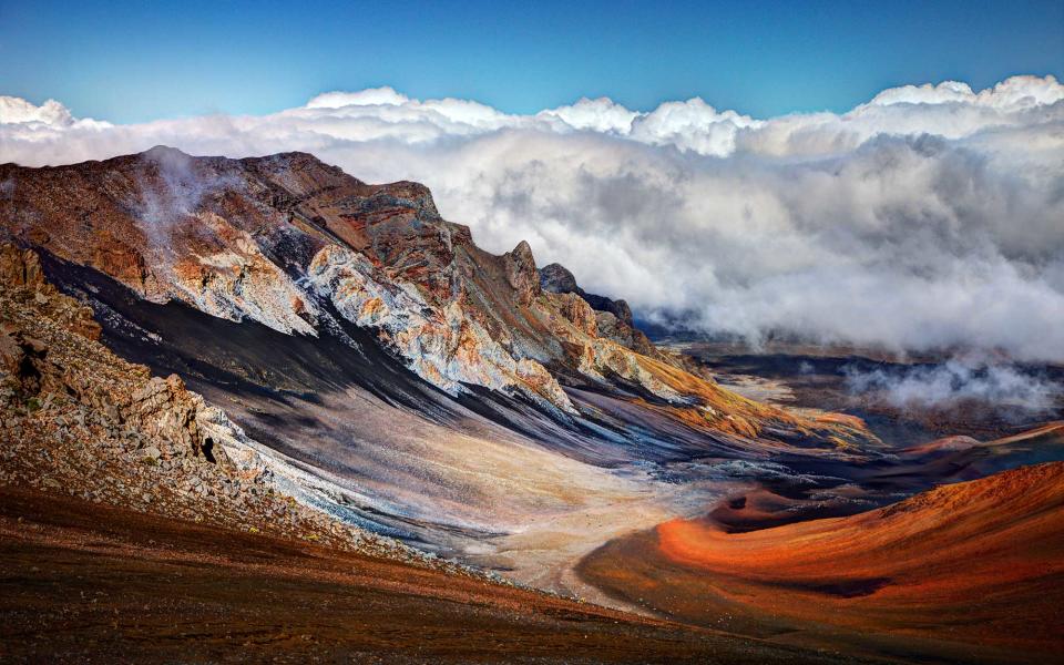 <p>While it’s tempting to spend your Hawaiian getaway in a cabana on a beach, sipping fruity, frothy cocktails, those who do only that during their visit to Maui will be cheating themselves of a beautiful, otherworldly escape. Located in the heart of the island, visitors to this National Park will remain busy for days on end. A drive to the 10,000-foot summit of the Haleakala Volcano to watch the sunrise or sunset is a Maui tradition—as is a loop around the coastal reaches of the park for spectacular views of deep blue waves and black sand beaches below. Many of the park’s most prominent attractions can also be reached by foot or by bike.</p>