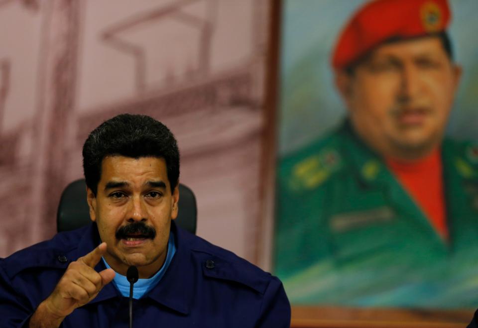 Venezuela's President Nicolas Maduro speaks next to a painting of the late Hugo Chavez, during a news conference at Miraflores Presidential Palace in Caracas, Venezuela, Friday, Feb. 21, 2014. Speaking Friday to international media, Maduro called out what he said was a "campaign of demonization to isolate the Bolivarian revolution." (AP Photo/Fernando Llano)