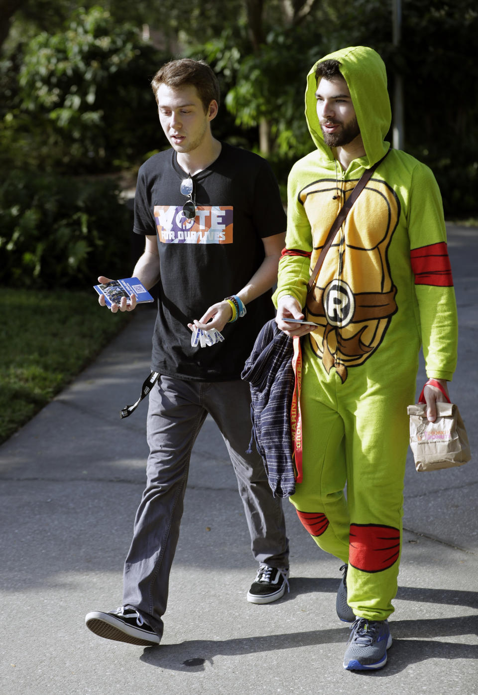 In this Wednesday, Oct. 31, 2018 photo, Bradley Thornton, left, a student volunteer, escorts Gabriel Sanchez to a polling place on campus during a Vote for Our Lives event at the University of Central Florida in Orlando, Fla. Nine months after 17 classmates and teachers were gunned down at their Florida school, Parkland students are finally facing the moment they’ve been leading up to with marches, school walkouts and voter-registration events throughout the country: their first Election Day. (AP Photo/John Raoux)