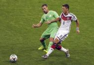 Germany's Mesut Ozil, right, and Algeria's Medhi Lacen challenge for the ball during the World Cup round of 16 soccer match between Germany and Algeria at the Estadio Beira-Rio in Porto Alegre, Brazil, Monday, June 30, 2014. (AP Photo/Thanassis Stavrakis)