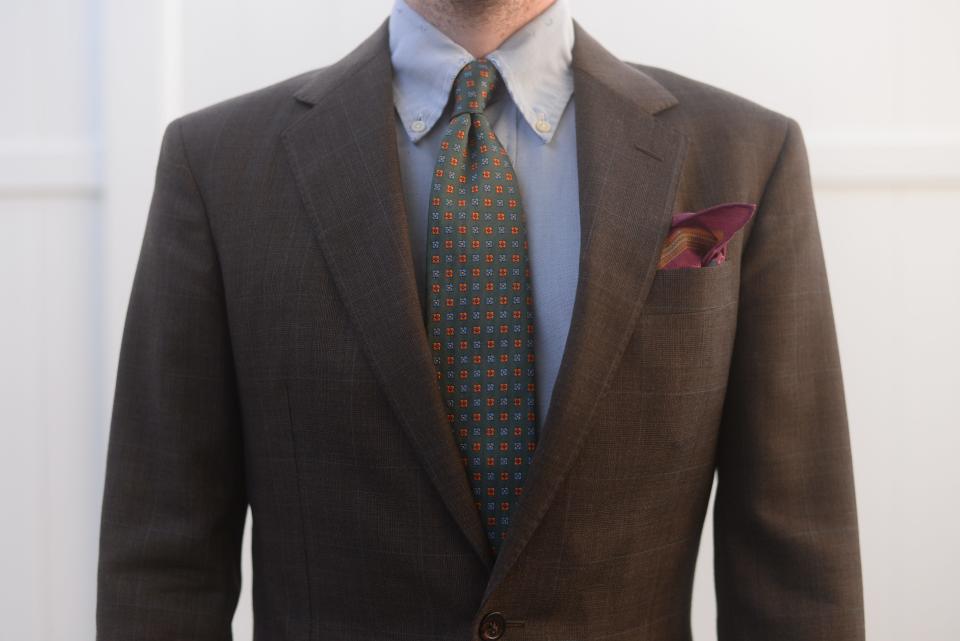 A close-up of a three-piece suit. The charcoal brown plaid has enough pattern to be worn as a sports coat but is formal enough for events like Homecoming.