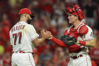 Cincinnati Reds' Art Warren, left, shakes hands with Tyler Stephenson after the final out of a baseball game against the Colorado Rockies in Cincinnati, Friday, June 11, 2021. (AP Photo/Aaron Doster)