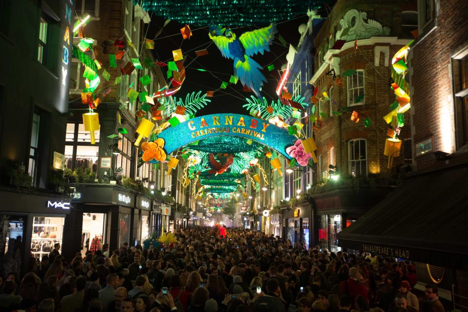 <p>Crowds gather for the Carnaby Christmas lights switch-on in Carnaby, London, which features a carnival theme. (PA) </p>