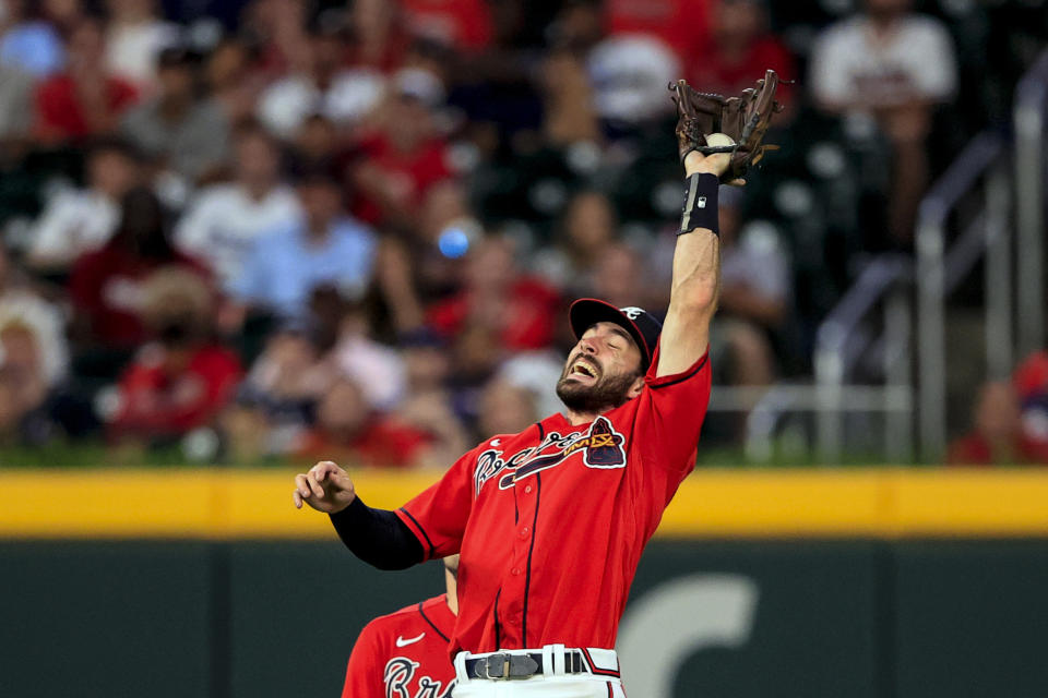 Atlanta Braves shortstop Dansby Swanson catches a pop fly for an out against Los Angeles Dodgers' Max Muncy during the ninth inning of a baseball game Friday, June 24, 2022, in Atlanta. (AP Photo/Butch Dill)