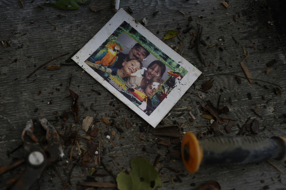 A photograph of an unknown family found by the Hudson family of Canada at their vacation home after the passage of Hurricane Ian rests alongside tools recovered from their storm-surge damaged garage level, near San Carlos Boulevard in Fort Myers Beach, Fla., Sunday, Oct. 2, 2022. (AP Photo/Rebecca Blackwell)