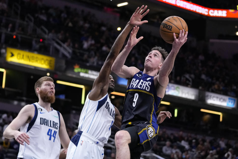 Indiana Pacers guard T.J. McConnell (9) shoots over Dallas Mavericks forward Justin Holiday (0) during the second half of an NBA basketball game in Indianapolis, Monday, March 27, 2023. The Mavericks defeated the Pacers 127-104. (AP Photo/Michael Conroy)