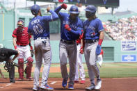 Toronto Blue Jays right fielder Teoscar Hernandez, center right, celebrates with Marcus Semien (10) and Bo Bichette, right, after Hernandez hit a three-run home run in the first inning of a baseball game, as Boston Red Sox's Kevin Plawecki, left, looks on, Sunday, June 13, 2021, in Boston. (AP Photo/Steven Senne)