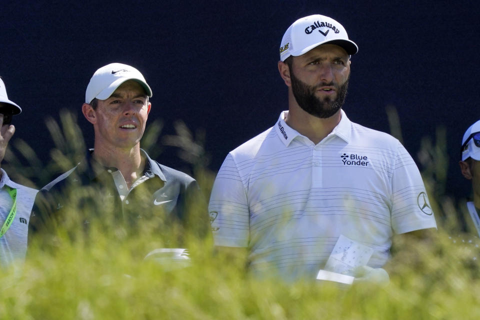 Rory McIlroy, left, of Northern Ireland, and Jon Rahm, of Spain, talk before teeing off at the fifth hole at The Country Club, Monday, June 13, 2022, in Brookline, Mass., during a practice round ahead of the U.S. Open golf tournament. (AP Photo/Robert F. Bukaty)