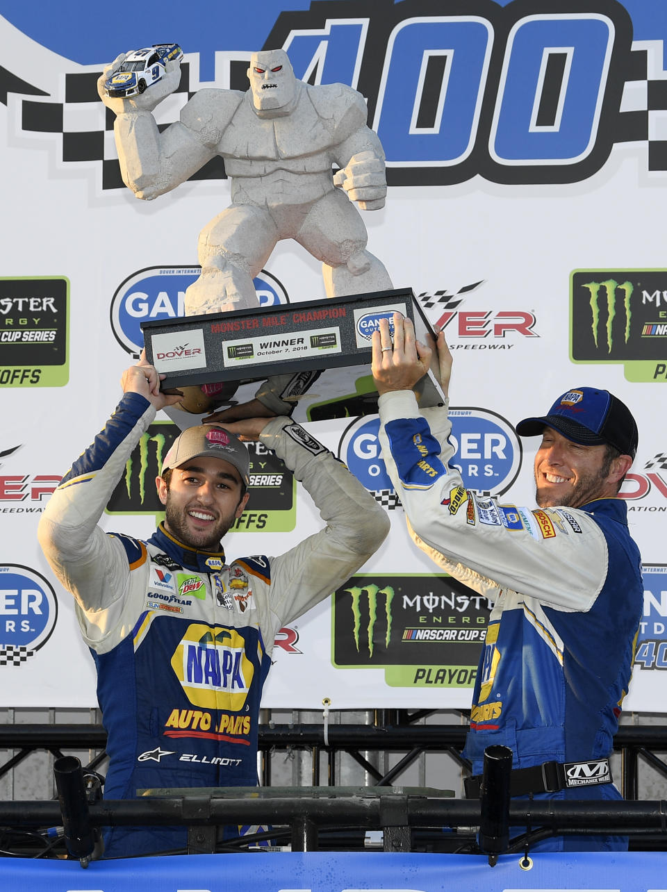 Chase Elliott, left, poses with the trophy in Victory Lane after winning a NASCAR Cup Series auto race, Sunday, Oct. 7, 2018, at Dover International Speedway in Dover, Del. (AP Photo/Nick Wass)