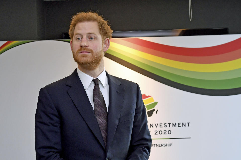 Prince Harry pictured in front of a colourful corporate sign