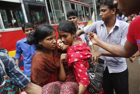 Colleagues carry Mina, a garment worker, as she fell sick during a protest in Dhaka September 23, 2013. REUTERS/Andrew Biraj
