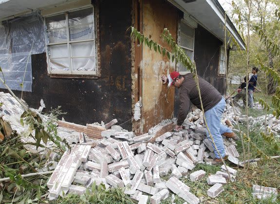 An Oklahoma man cleans up the bricks that fell from three sides of his in-laws home in Sparks, Nov. 6, 2011, after two earthquakes hit the area in less than 24 hours.