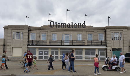Tourists walk past the entrance to 'Dismaland', a theme park-styled art installation by British artist Banksy, at Weston-Super-Mare in southwest England