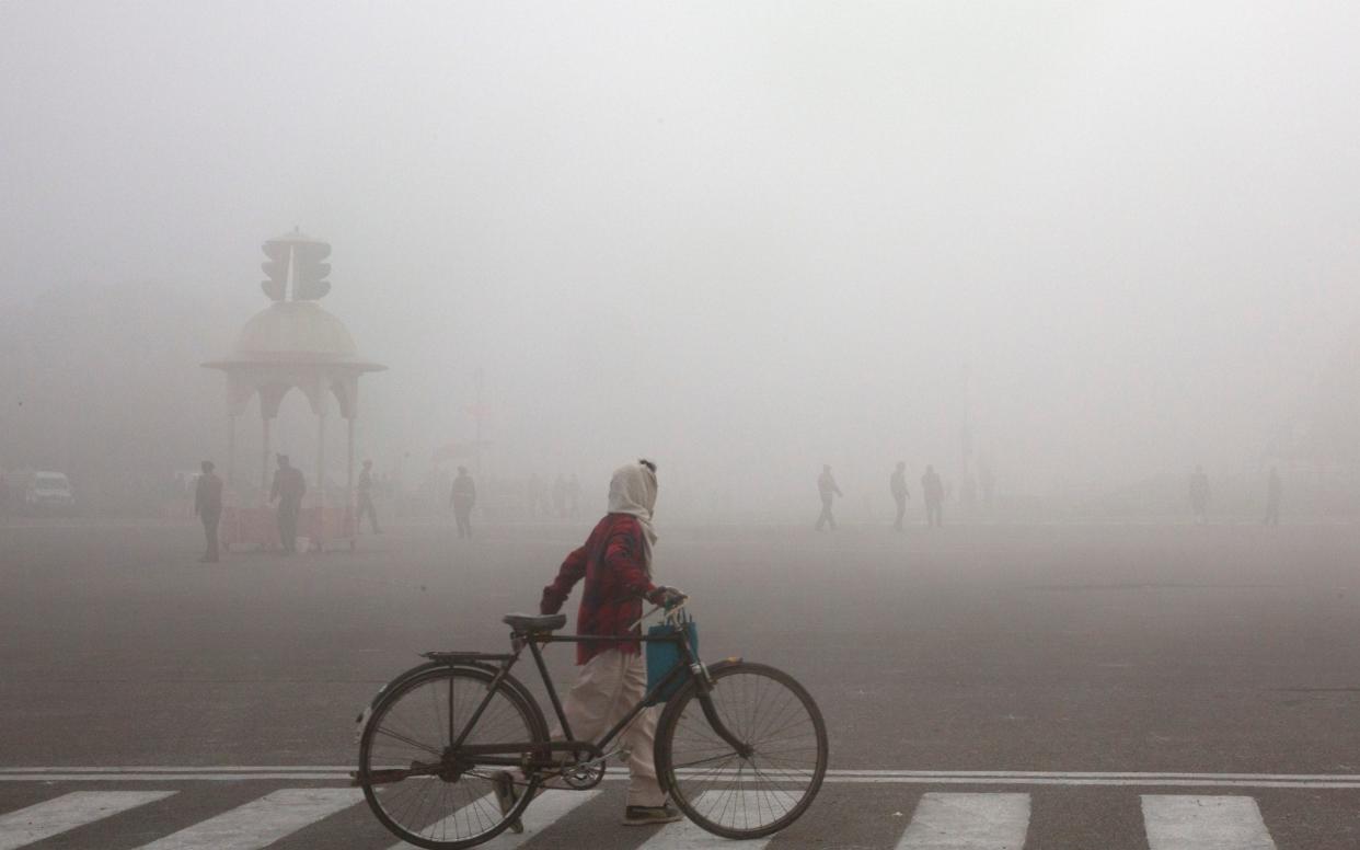 A cyclist amid morning smog in Delhi earlier this year - AP