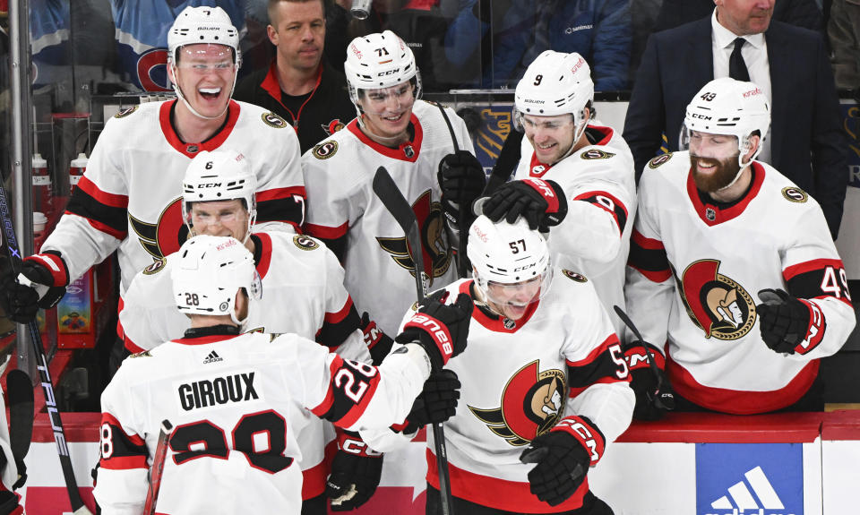 Ottawa Senators' Shane Pinto (57) celebrates with teammates after scoring against the Montreal Canadiens during the second period of an NHL hockey game in Montreal, Tuesday, Jan. 23, 2024. (Graham Hughes/The Canadian Press via AP)