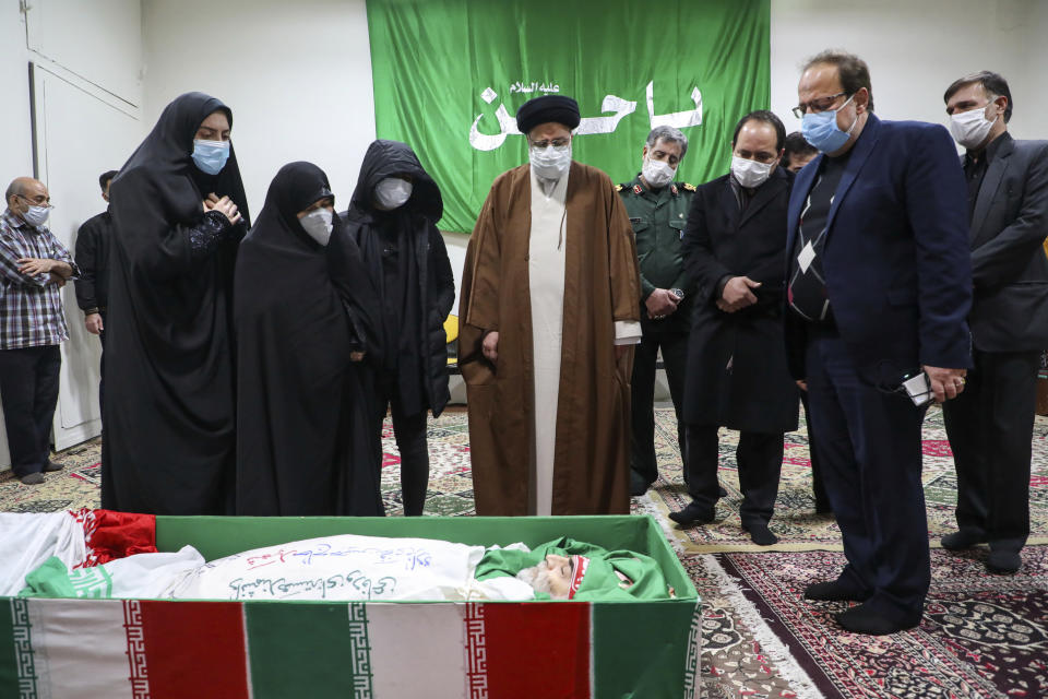 Iran's Judiciary Chief Ayatollah Ebrahim Raisi pays his respect to the body of slain scientist Mohsen Fakhrizadeh among his family, in Tehran, Iran, Saturday, Nov. 28, 2020. Iranian officials have blamed Israel for the killing of Fakhrizadeh who led Tehran's disbanded military nuclear program. (Mizan News Agency via AP)