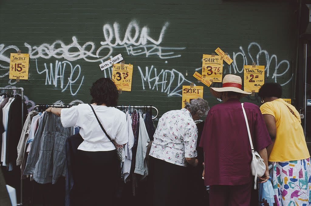 Women look at clothes at an outdoor stall in the East Village, Manhattan, New York City, USA, June 1982.