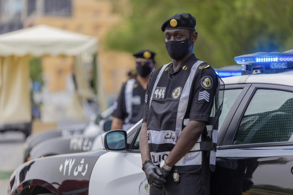 Policemen wearing gloves and face masks to help prevent the spread of the coronavirus, provide security for pilgrims, in Mecca, Saudi Arabia, Sunday, July 26, 2020. Only about 1,000 pilgrims will be allowed to perform the annual hajj pilgrimage that begins later this month due to the virus pandemic. (Saudi Ministry of Media via AP)