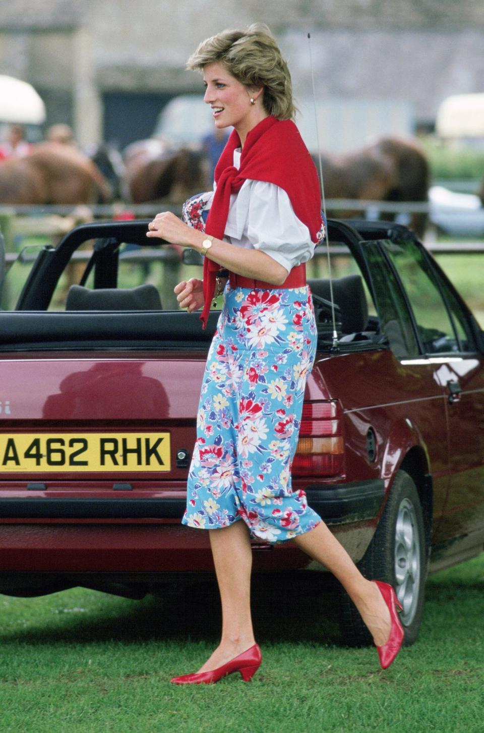 <p>Princess Diana had the perfect practical accessory at a polo game in 1985, casually tying a red sweater (which complemented her floral pants and matched her shoes) over her shoulders.</p>