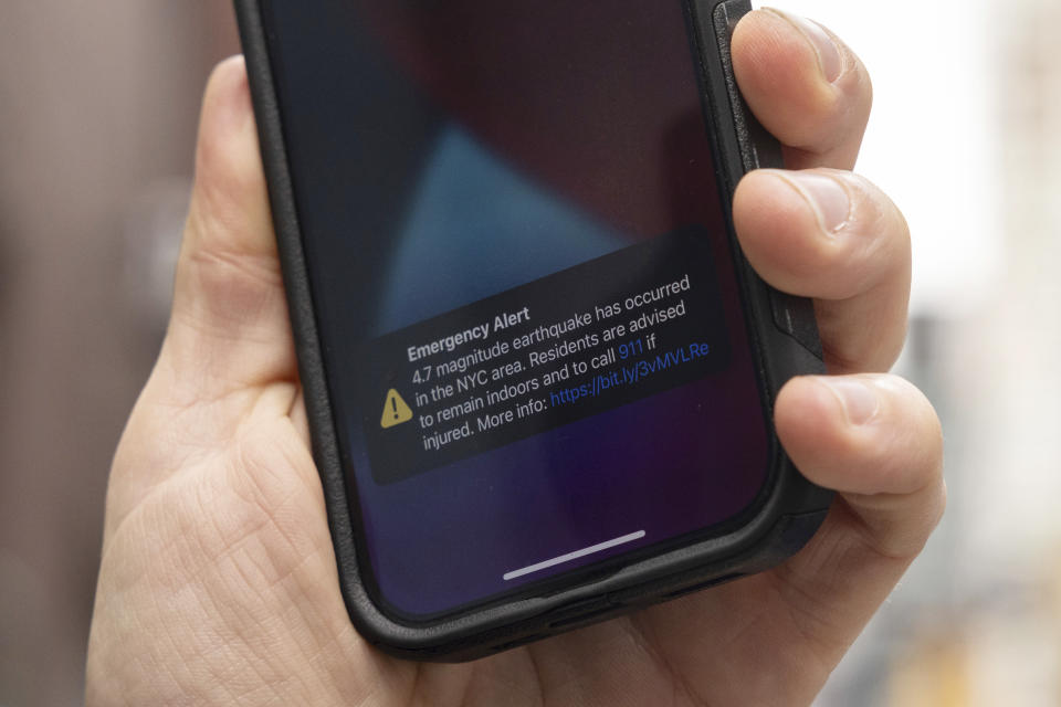 A person looks at an emergency alert on their smartphone Friday, April. 5, 2024, in New York. (Yuki Iwamura/AP)
