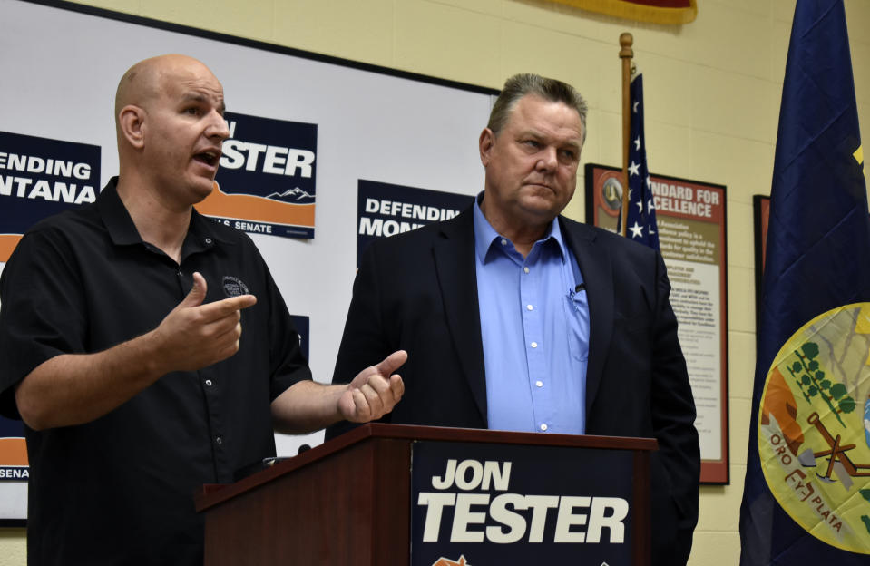 This Aug. 31, 2018 photo shows Montana U.S. Sen. Jon Tester, right, listening to Brandon Judd, president of the National Border Patrol Council, speak about border security and immigration during a campaign event in Billings, Mont. Outside groups and donors have poured more than $45 million into the race between Tester and Republican State Auditor Matt Rosendale. (AP Photo/Matthew Brown)