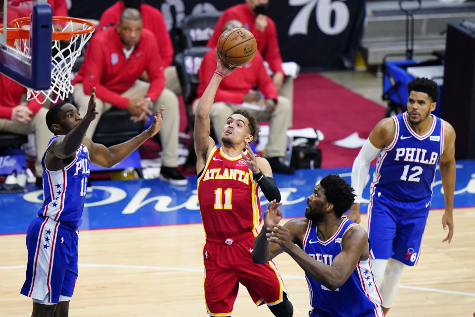 Atlanta Hawks' Trae Young, center, goes up for a shot between Philadelphia 76ers' Shake Milton, left, and Joel Embiid during the second half of Game 2 in a second-round NBA basketball playoff series, Tuesday, June 8, 2021, in Philadelphia. (AP Photo/Matt Slocum)