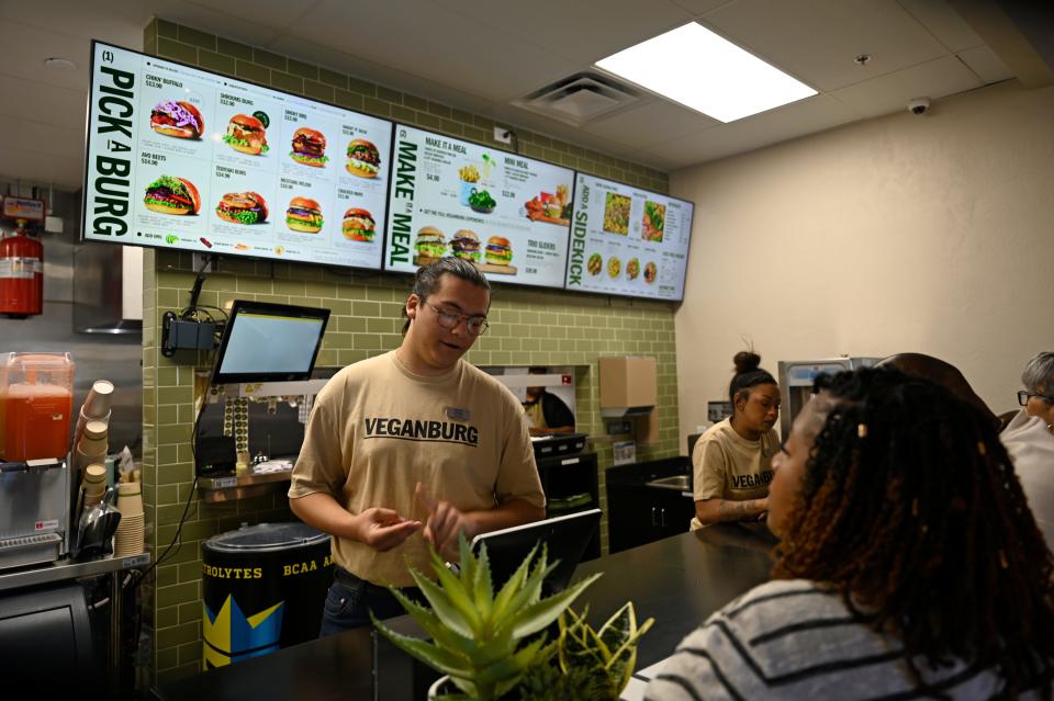 A Veganburg employee begins to take the restaurant's first orders from customers during the soft opening on Monday, April 15, 2024 in Hesperia.