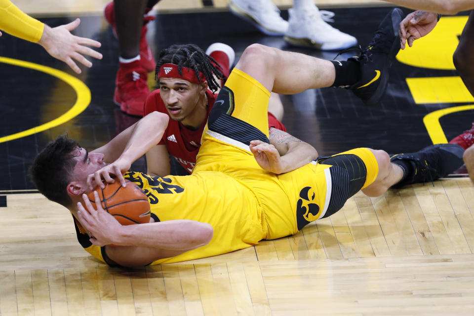 Iowa center Luka Garza, left, fights for a loose ball with Rutgers guard Caleb McConnell during the first half of an NCAA college basketball game, Wednesday, Jan. 22, 2020, in Iowa City, Iowa. (AP Photo/Charlie Neibergall)