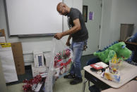 Charles Fabian, facilities manager at Queen of the Rosary Catholic Academy, sorts through classroom materials that can be donated, Thursday, Aug. 6, 2020, in Brooklyn borough of New York. In July the Archdiocese of Brooklyn and Queens announced that six Catholic schools in the two boroughs will close permanently at the end of August due to debt and low enrollment aggravated by the coronavirus pandemic. (AP Photo/Jessie Wardarski)