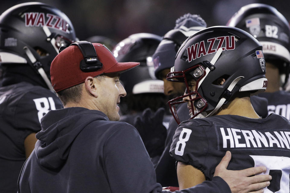 Washington State coach Jake Dickert, left, speaks with wide receiver Carlos Hernandez (8) during the first half of the team's NCAA college football game against Colorado, Friday, Nov. 17, 2023, in Pullman, Wash. (AP Photo/Young Kwak)