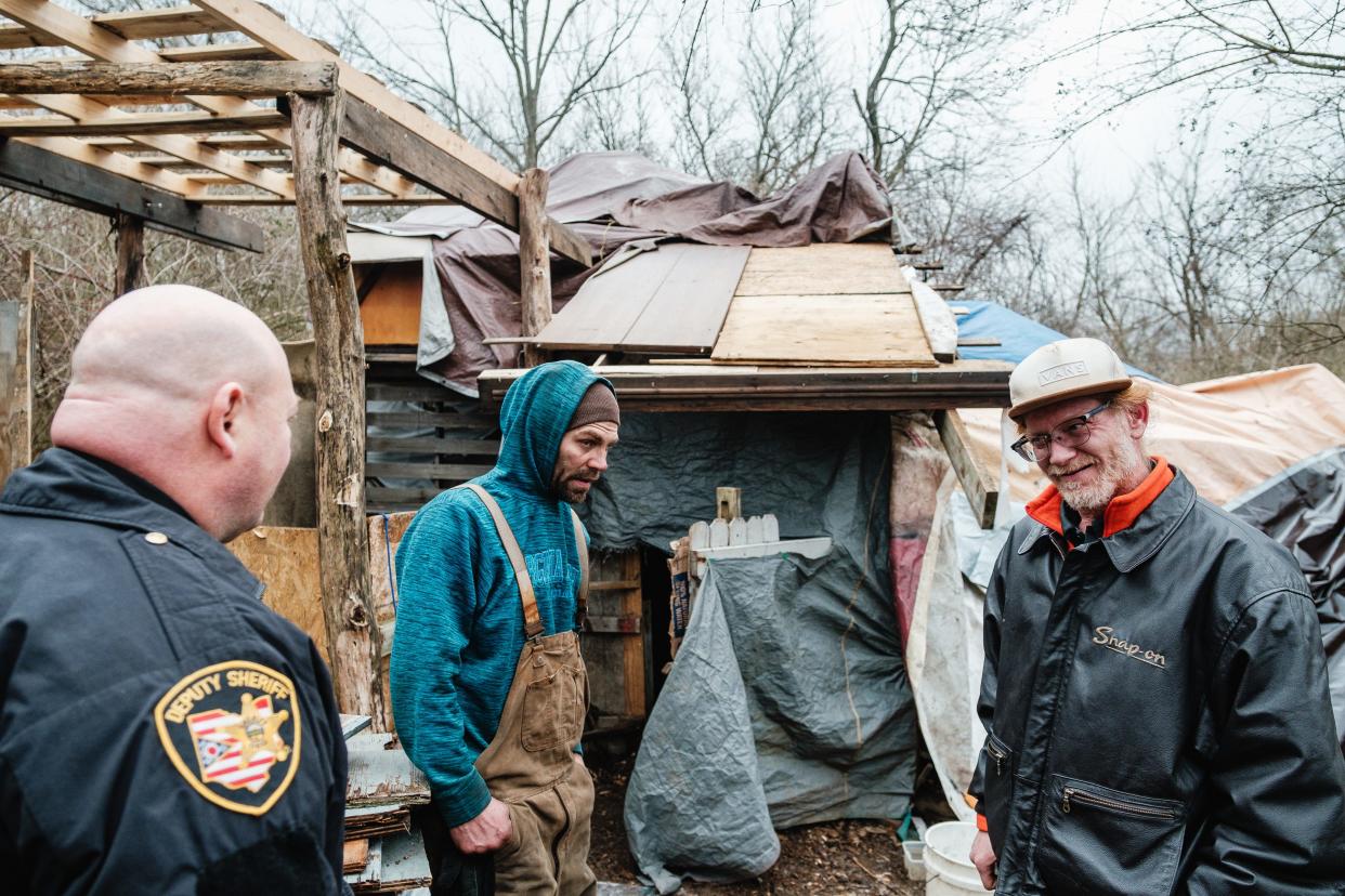 Captain Travis Stocker with the Tuscarawas County Sheriff's Office talks with two men about occupying what the city of New Philadelphia has deemed a homeless encampment off Fourth Street Extension SE on Wednesday, Jan. 31. The men said they do have other places to go for shelter.