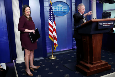 U.S. National Security Advisor John Bolton answers questions from reporters after announcing that the U.S. will withdraw from the Vienna protocol and the 1955 "Treaty of Amity" with Iran as White House Press Secretary Sarah Huckabee Sanders looks on during a news conference in the White House briefing room in Washington, U.S., October 3, 2018. REUTERS/Leah Millis