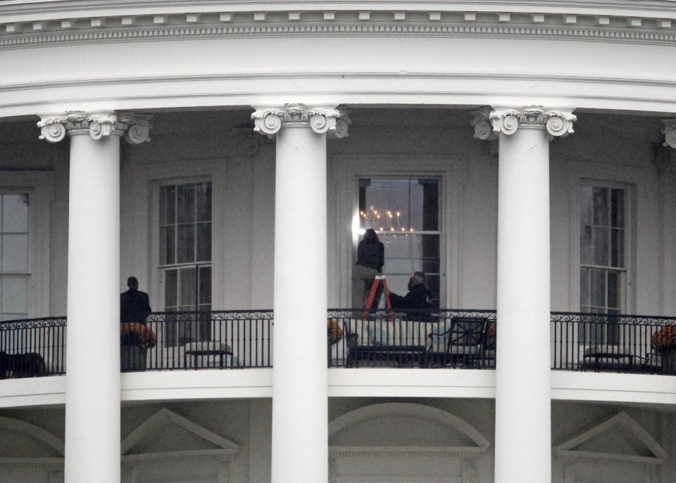 FILE - This Nov. 16, 2011 file photo shows law enforcement officers photographing a window at the White House in Washington, as seen from the South Lawn. A bullet hit an exterior window of the White House and was stopped by ballistic glass, the Secret Service said. An additional round of ammunition was found on the White House exterior. The bullets were found Tuesday morning. An Idaho man who pleaded guilty to shooting at and hitting the White House is set to be sentenced. Prosecutors say Oscar Ramiro Ortega-Hernandez should spend 27 years in prison for the 2011 shooting. His sentencing is scheduled for Monday afternoon. No one was injured, but prosecutors say Ortega-Hernandez hit the executive mansion about eight times and did nearly $100,000 in damage. (AP Photo/Haraz N. Ghanbari, File)