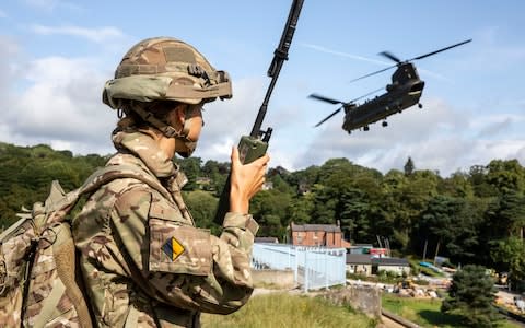 RAF personnel were pivotal in saving the Toddbrook Reservoir dam near the village of Whaley Bridge. Here a Chinook Mk6a helicopter is directed from the ground as it approaches the dam. Aug 6, 2019. - Credit: Cpl Rob Travis/MoD/PA