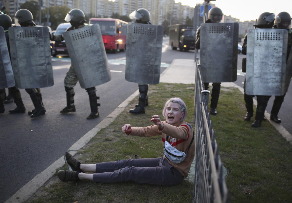 FILE - In this Wednesday, Sept. 23, 2020 file photo, a woman reacts in front of police line during a rally in Minsk, Belarus. Belarus President Alexander Lukashenko has relied on massive arrests and intimidation tactics to hold on to power despite nearly three months of protests sparked by his re-election to a sixth term, but continuing protests have cast an unprecedented challenge to his 26-year rule. (AP Photo/TUT.by, File)