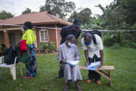 Election officials prepare a polling station in Kampala, Uganda, Thursday, Jan. 14, 2021. Ugandans are voting in a presidential election tainted by widespread violence that some fear could escalate as security forces try to stop supporters of leading opposition challenger BobiWine from monitoring polling stations.(AP Photo/Jerome Delay)