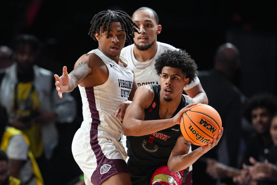 Winston-Salem State guard Isaac Parson (5) is defended by Virginia Union guard Travis Vaughn (2) during the first half of the HBCU Classic NCAA college basketball game in Indianapolis, Saturday, Feb. 17, 2024. (AP Photo/Michael Conroy