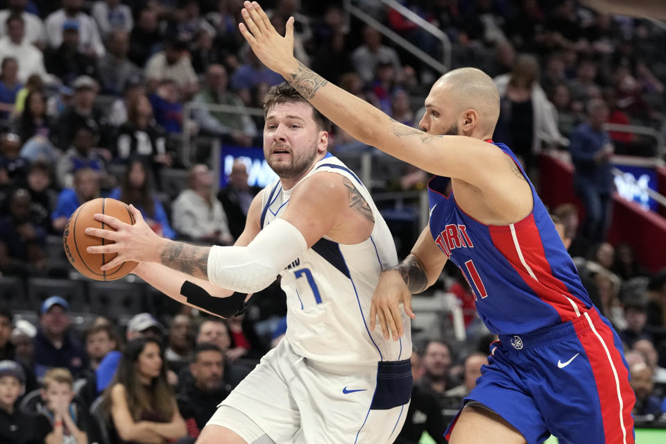 Dallas Mavericks guard Luka Doncic (77) is defended by Detroit Pistons guard Evan Fournier during the second half of an NBA basketball game, Saturday, March 9, 2024, in Detroit. (AP Photo/Carlos Osorio)