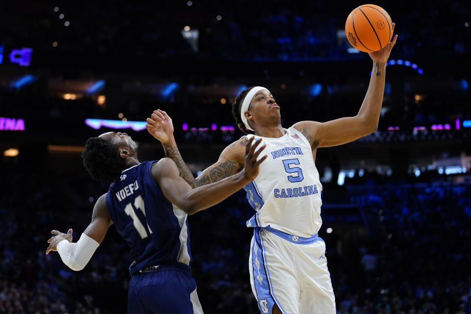 North Carolina's Armando Bacot, right, collides with St. Peter's KC Ndefo during the first half of a college basketball game in the Elite 8 round of the NCAA tournament, Sunday, March 27, 2022, in Philadelphia. (AP Photo/Matt Rourke)