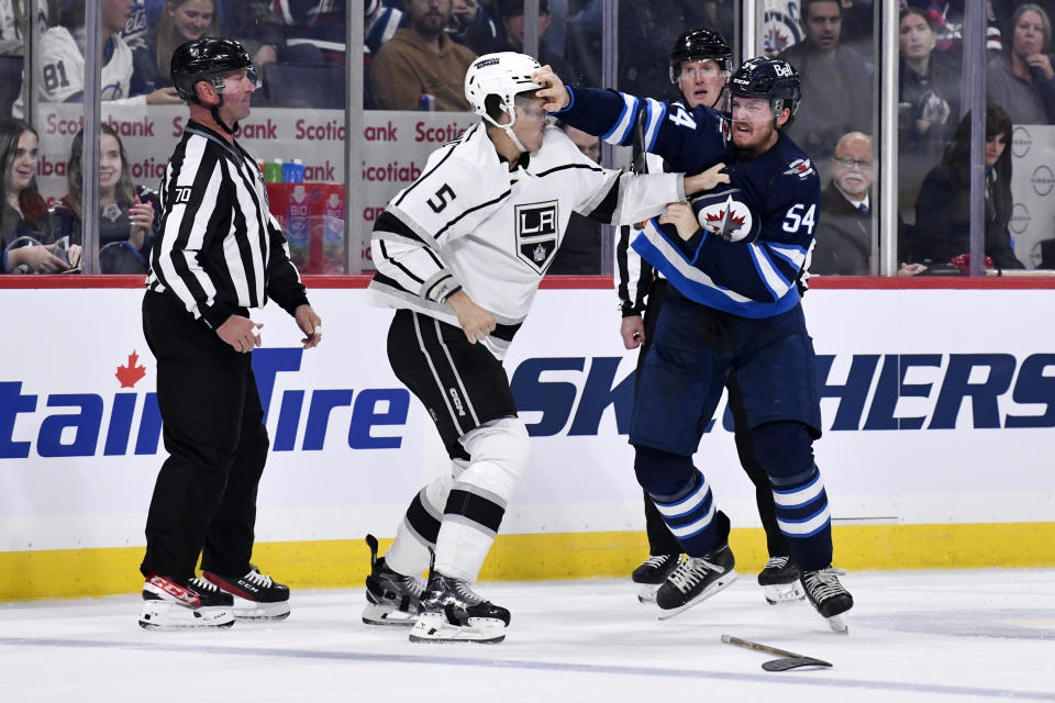 Los Angeles Kings' Andreas Englund (5) fights Winnipeg Jets' Dylan Samberg (54) during the second period of an NHL hockey game, Tuesday, Oct. 17, 2023 in Winnipeg, Manitoba. (Fred Greenslade/The Canadian Press via AP)