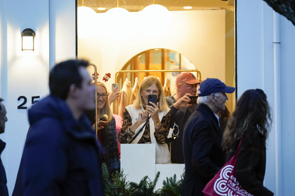 People watch as President Joe Biden, second from right, visits shops in Nantucket, Mass., Friday, Nov. 24, 2023. (AP Photo/Stephanie Scarbrough)