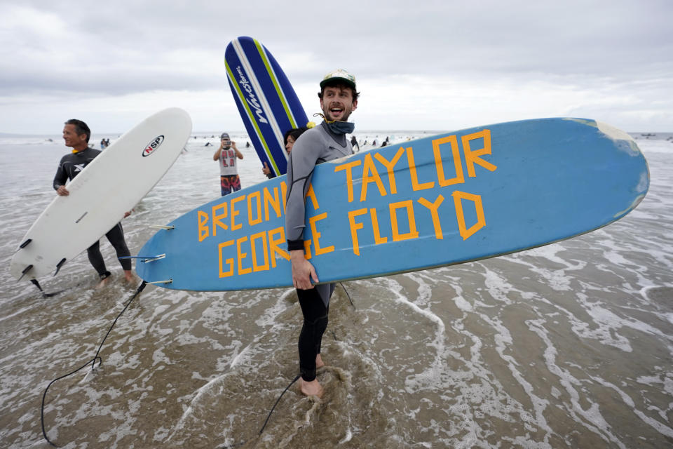 Surfers participate in a paddle out ceremony at "The Ink Well," a beach historically known as a surfing refuge for African Americans, to honor the life of George Floyd on Friday, June 5, 2020, in Santa Monica, Calif. Floyd died after he was restrained in police custody on Memorial Day in Minneapolis. (AP Photo/Ashley Landis)