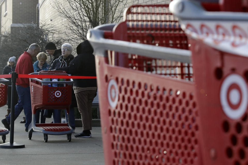 Shoppers wait to enter at a Target store in Glenview, Ill., Wednesday, March 25, 2020. Grocery store chains and other retailers began offering special shopping hours for seniors and other groups considered the most vulnerable to the new coronavirus. The new coronavirus cause mild or moderate symptoms for most people, but for some, especially older adults and people with existing health problems, it can cause more severe illness or death. (AP Photo/Nam Y. Huh)