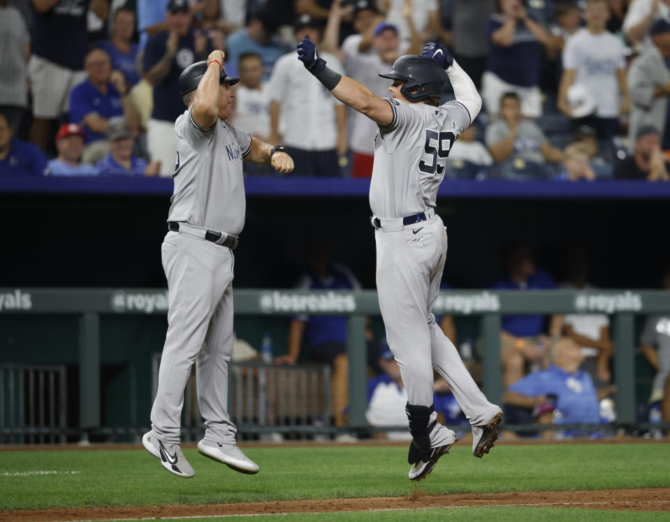 New York Yankees third base coach Phil Nevin, left, congratulates Luke Voit, right after hitting a home run during the ninth inning of a baseball game against the Kansas City Royals at Kauffman Stadium in Kansas City, Mo., Monday, Aug. 9, 2021. (AP Photo/Colin E. Braley)