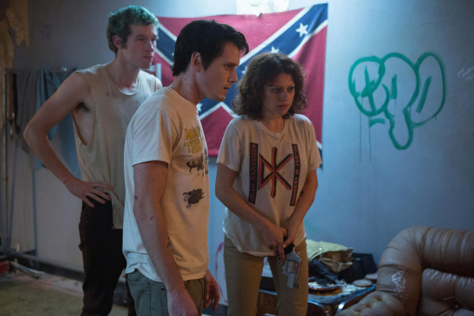 Callum Turner, Anton Yelchin, and Alia Shawkat stand in a room with a Confederate flag