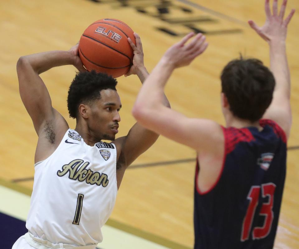 Akron Zips guard Loren Christian Jackson looks to pass as Malone guard Simon Blair defends at Rhodes Arena, Saturday, Dec. 19, 2020.