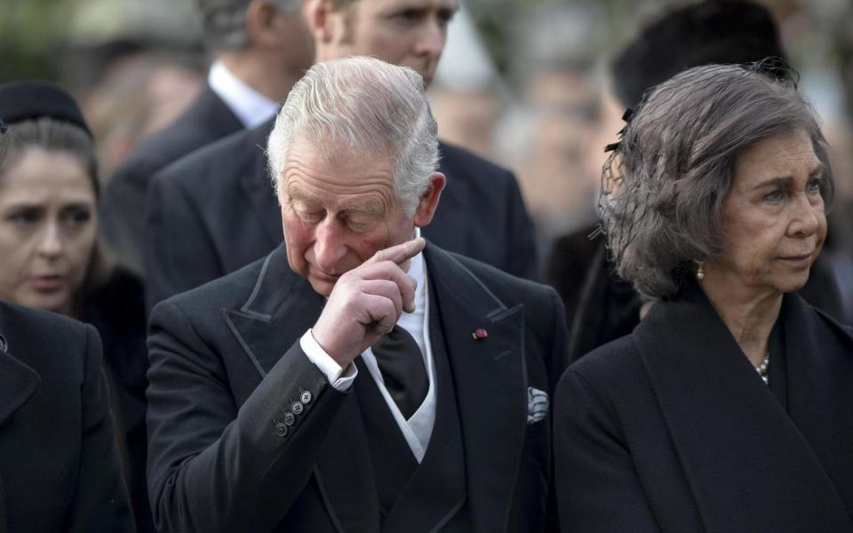 Britain's Prince Charles, left, wipes his face as former Spanish Queen Sofia, right, looks on (PA)