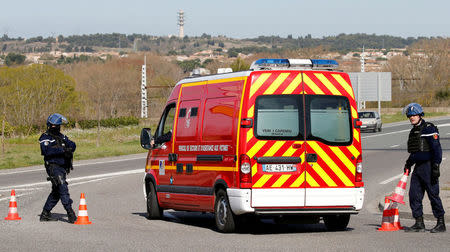 French gendarmes and a firefighters ambulance are seen on a road blockade after a hostage situation at a supermarket in Trebes, France, March 23, 2018. REUTERS/Regis Duvignau