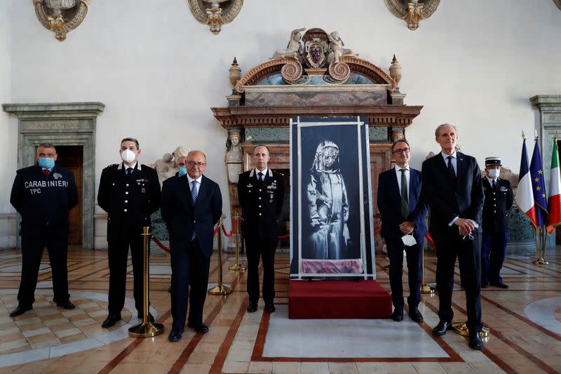 Foto del martes de la ceremonia de entrega a las autoridades de Francia de una puerta del teatro Bataclan con un mural pintado por Banksy recuperada en Italia tras su robo