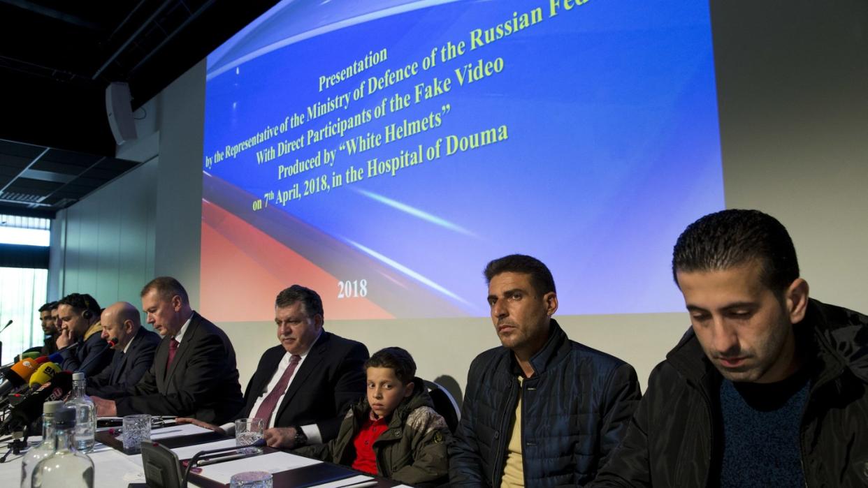 Mehrere der Syrer, die von Russland als vermeintliche Zeugen präsentiert wurden, nehmen in Den Haag an einer Pressekonferenz teil. Foto: Peter Dejong/AP